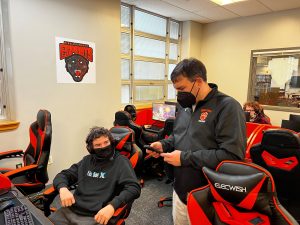 Coach Bud Morey coordinates with competitors from another school during a remote esports competition in the Garden State League