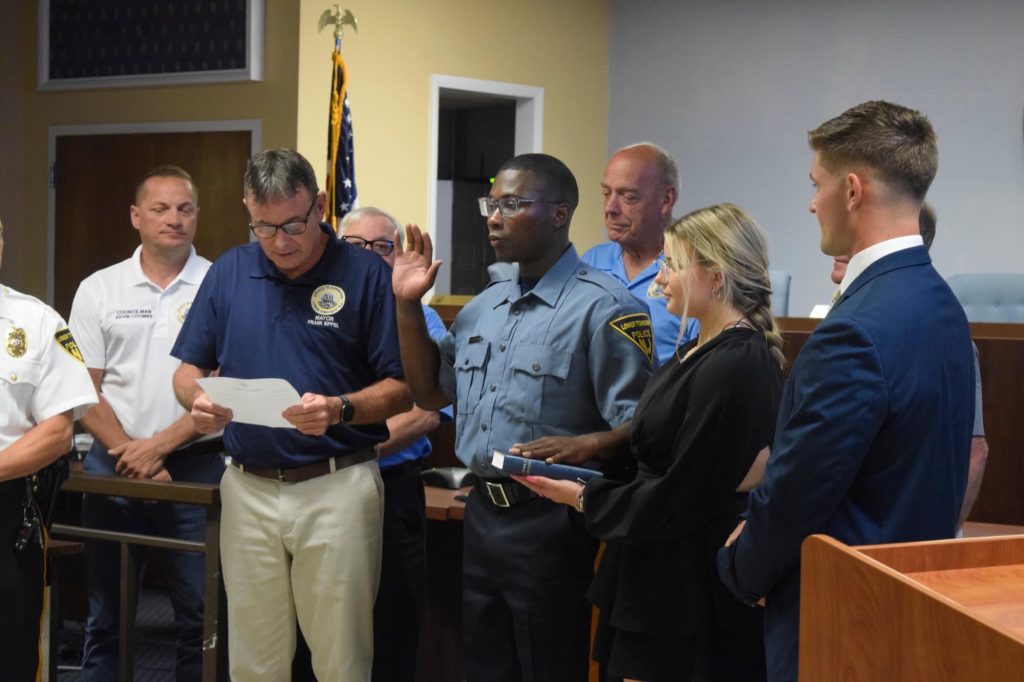 Simba Elam-Hampton is sworn in as Lower Township Police Department's newest Patrol Officer by Lower Mayor Frank Sippel as his girlfriend Georgia Papamarkos holds the bible