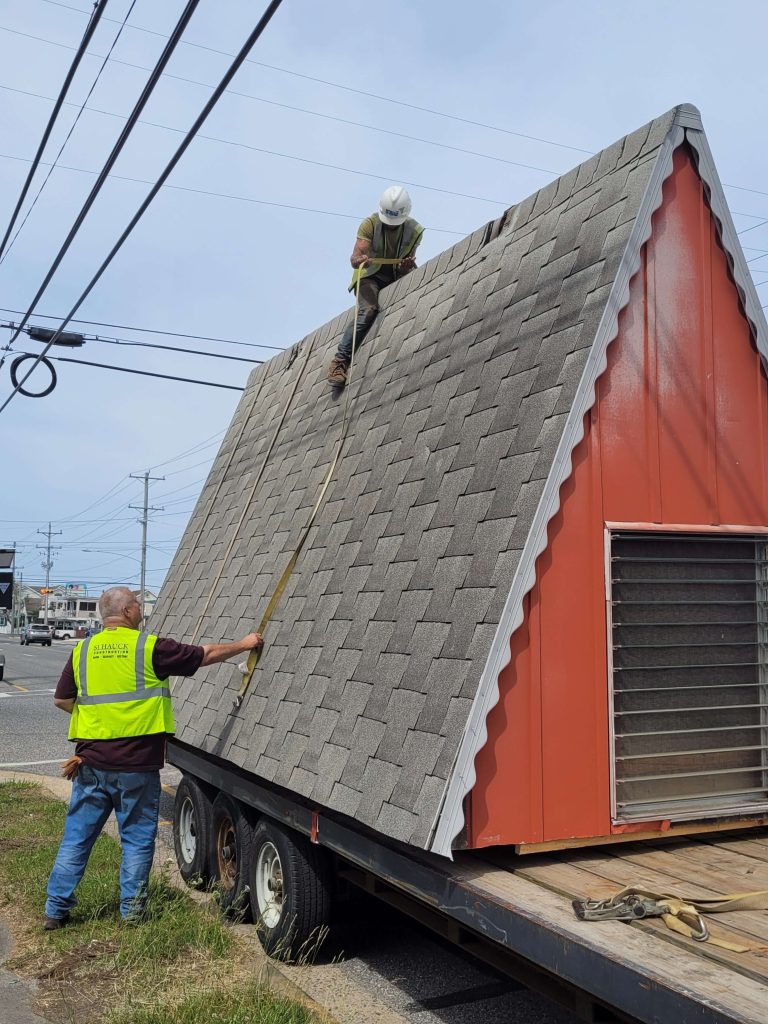 Members of SJ Hauck Construction strap down the top half of an A-frame building that was moved June 7 from Wildwood to Woodbine. The building was reinforced to prep it for the move.  