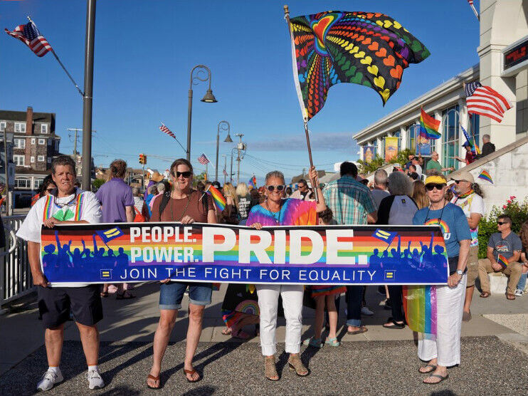 Equality Cape May members hold a banner together at the 2021 pride march.