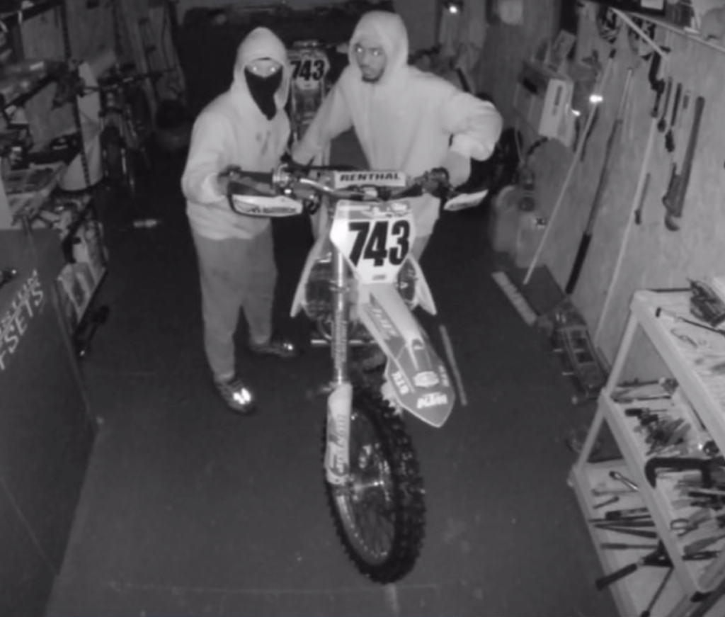 The suspects are pictured stealing a bike.