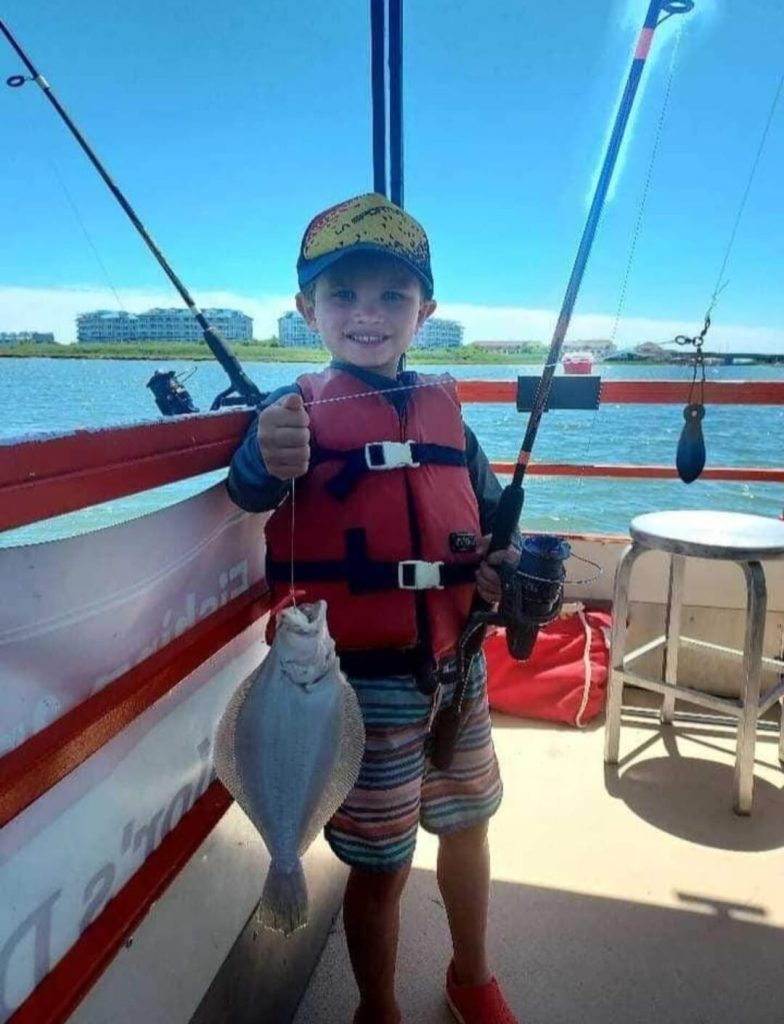 A happy young angler with his flounder. 
