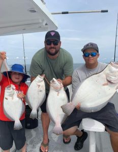 Three happy anglers with a 6.2-pound flounder (on right side).