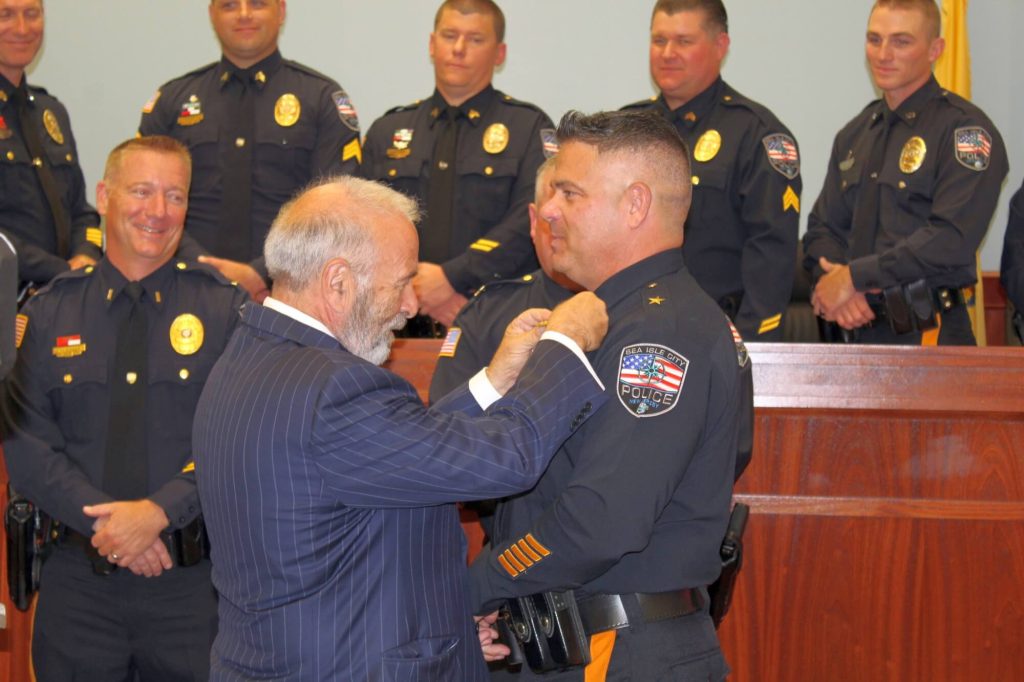 Mayor Leonard Desiderio is shown pinning a new badge on the uniform of Chief Anthony Garreffi