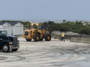 North Wildwood city employees move concrete barriers in place to protect the beach patrol facilities between the end of 15th and 16th avenues Oct. 5