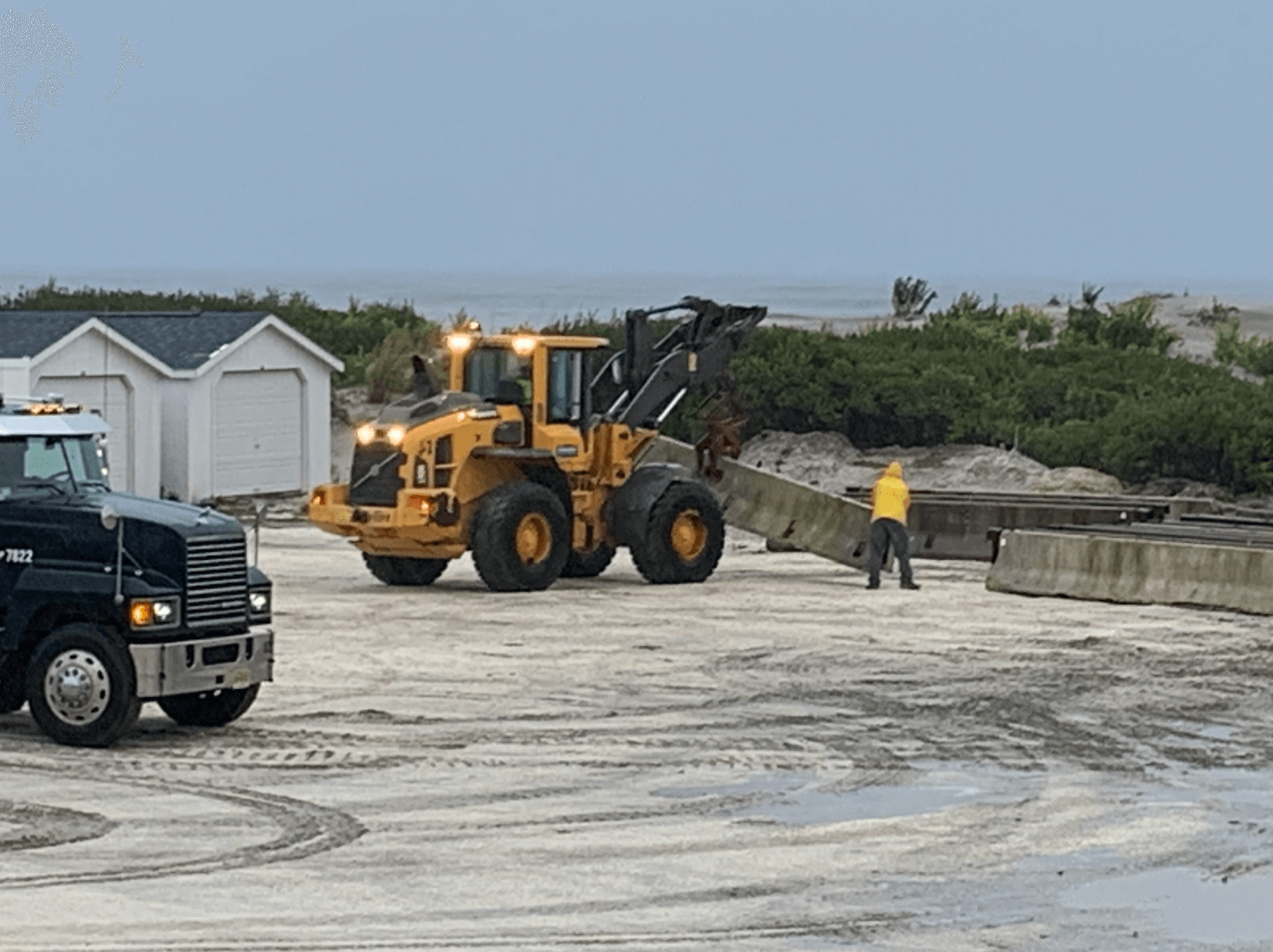 North Wildwood city employees move concrete barriers in place to protect the beach patrol facilities between the end of 15th and 16th avenues Oct. 5