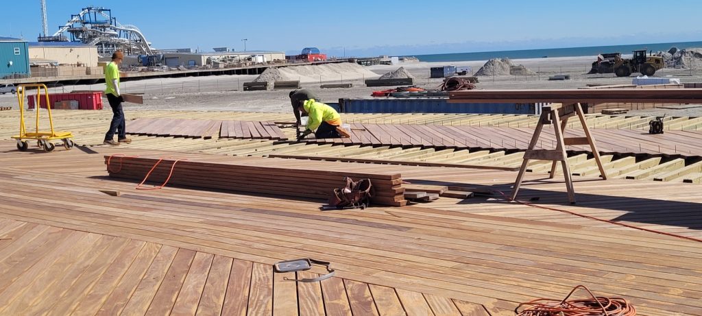 Workers replace decking on the Wildwood Boardwalk in March 2023 as part of an ongoing reconstruction project.