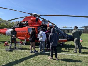 Middle Township students surround a US Coast Guard helicopter for a tour after a surprise field landing.