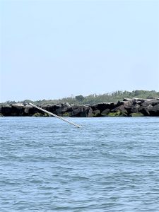 The mast of a sailboat sticks out of about 20 feet of water near Cape May Inlet. The boat