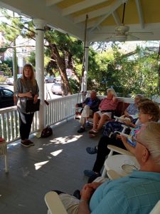 Gayle Stahlhuth reading a story on the porch of The Dormer House 