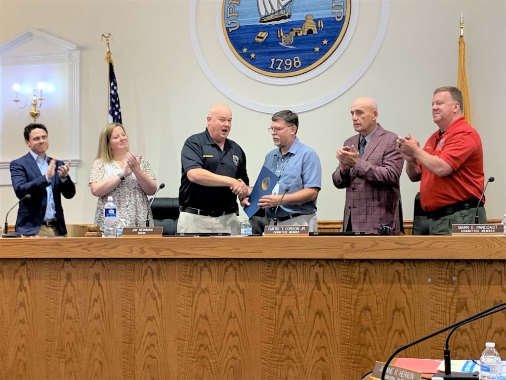 Members of the Upper Township Committee applaud and congratulate Paul Dietrich